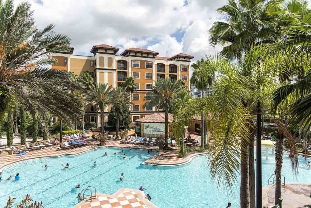 Two outdoor heated pools at Floridays Resort Orlando with umbrellas, open from 7 AM to 11 PM