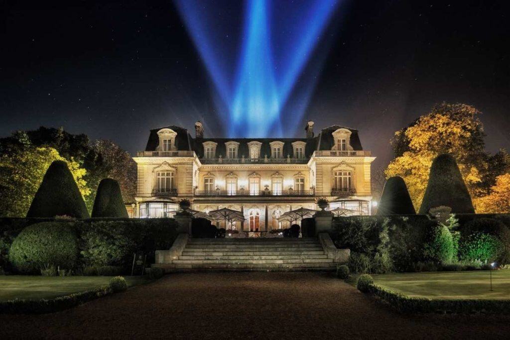 Domaine Les Crayères facade with central entrance surrounded by manicured gardens in France