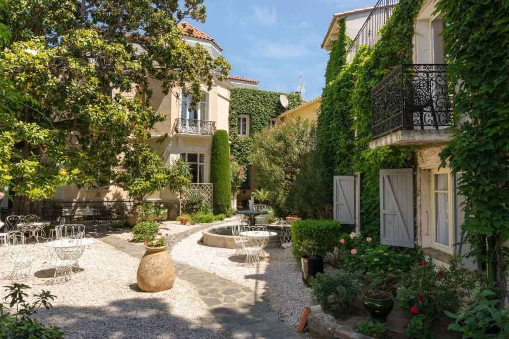 Serene courtyard at Hôtel La Casa Païral with lush greenery and a central fountain