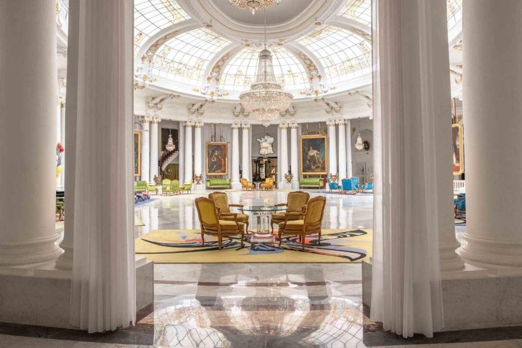 Elegant high-ceiling lobby at Hotel Le Negresco in Nice with central seating and fine artwork