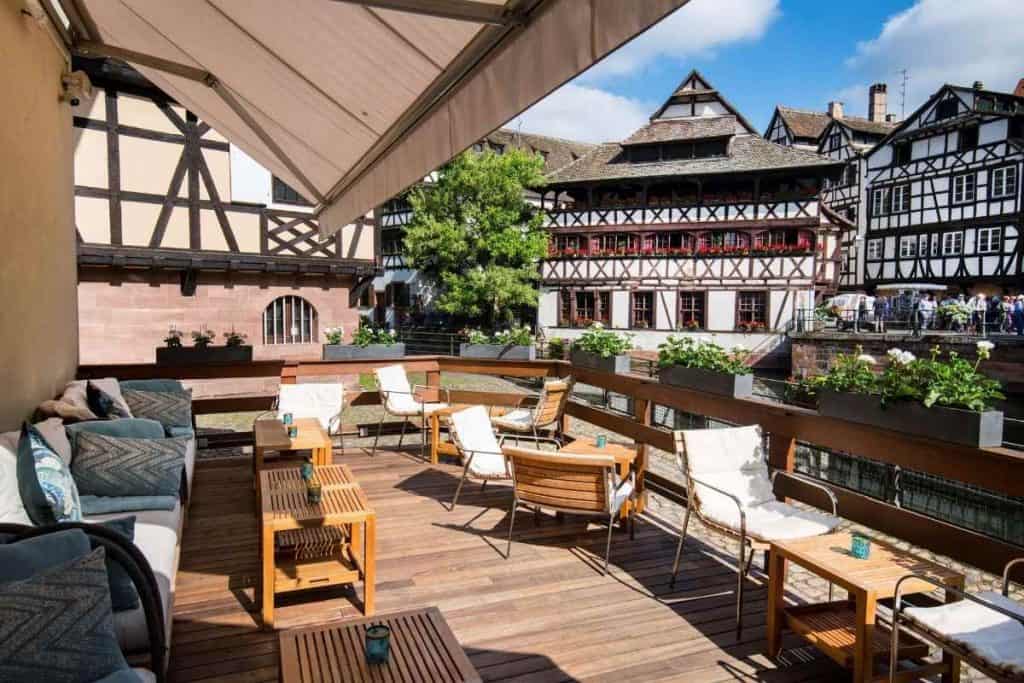 Terrace seating at Hôtel & Spa RÉGENT PETITE FRANCE overlooking canals and half-timbered houses
