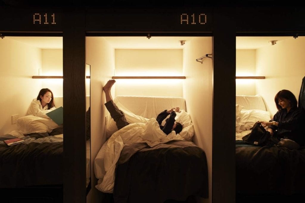 Three capsule pods at The Millennials Shibuya with female travelers relaxing inside