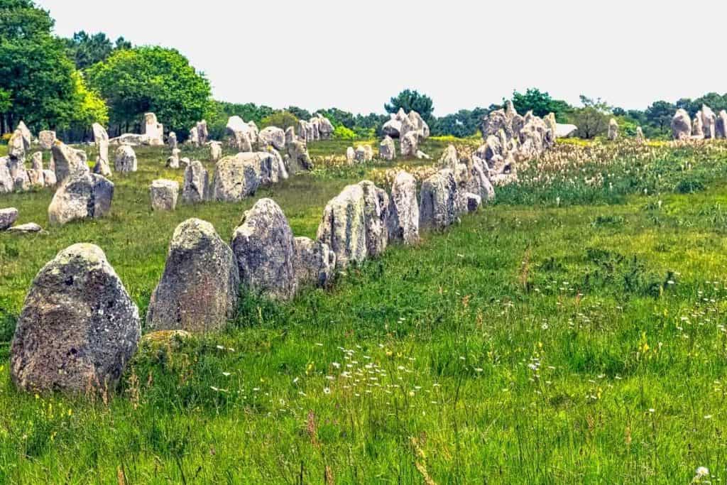 Ancient stone alignments at Carnac stretching across the Brittany landscape — a 6,000-year-old enigma older than Stonehenge, shrouded in mystery and local legend.