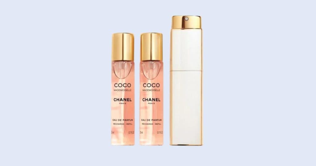 Chanel Coco Mademoiselle Eau de Parfum travel spray on clean light blue background