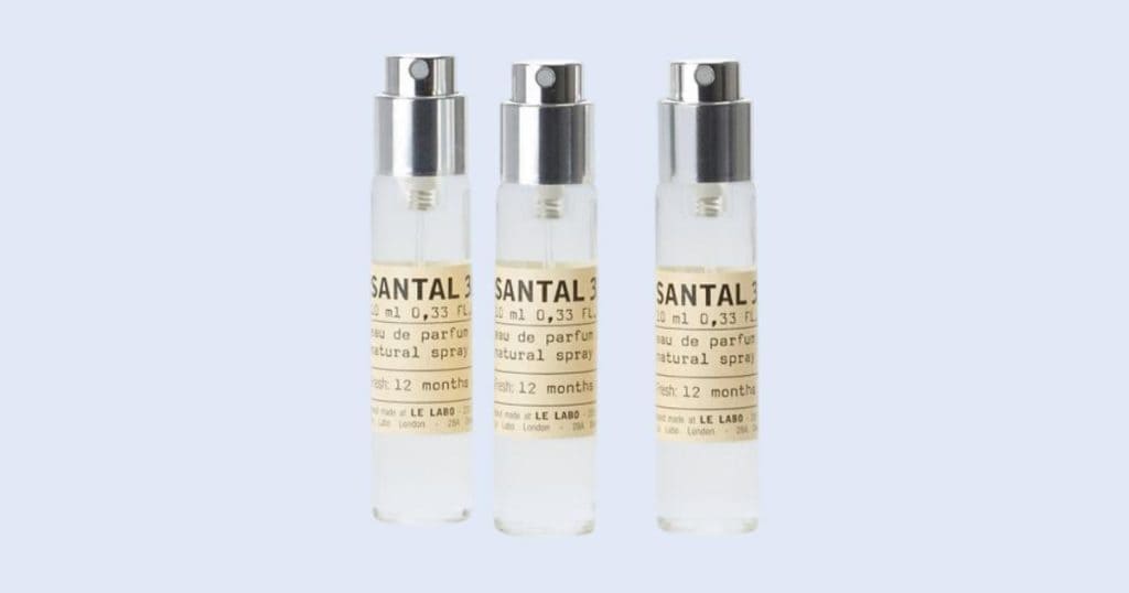 Le Labo Santal 33 travel spray perfume on light blue background