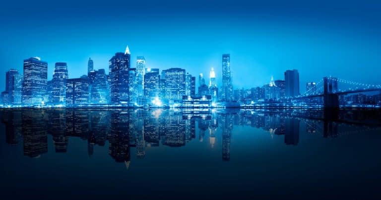 New York City skyline at night with illuminated Manhattan skyscrapers and reflections on the East River